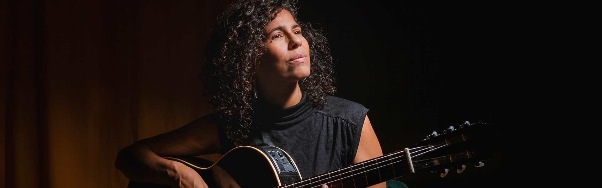 Alicia Canguero, artista musical posando con su guitarra.